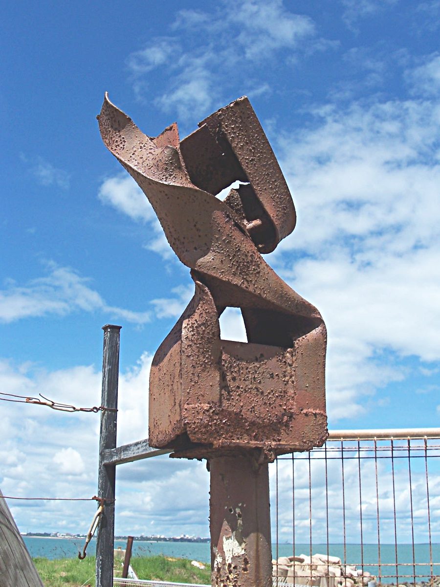 The base of a steel electricity pole bent by tracy